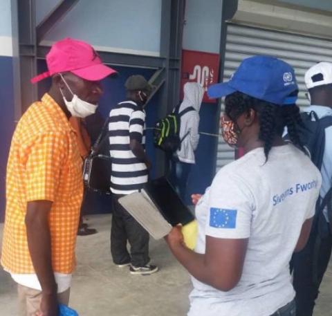 IOM staff member speaking with a migrant